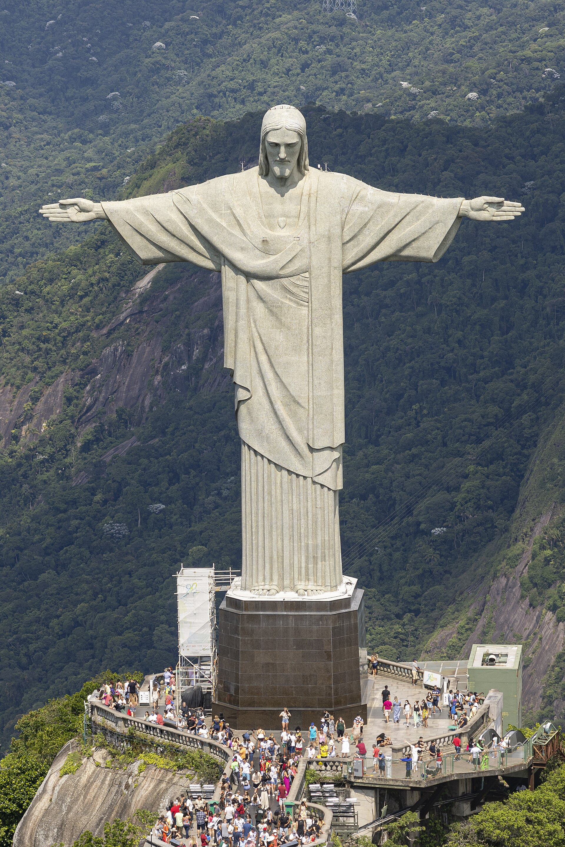 Estátua do Cristo Redentor vista de cima, no topo do Corcovado, com o mirante e a floresta da Tijuca.